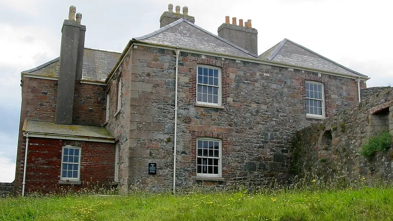 Old stone house with a slate roof and brick chimneys